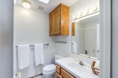 a bathroom with a sink and a toilet and a mirror at Fun-Filled Backyard Bakersfield Family Haven! in Bakersfield