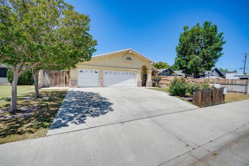 a house with a driveway with a garage at Fun-Filled Backyard Bakersfield Family Haven! in Bakersfield