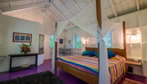 ein Schlafzimmer mit einem Himmelbett in der Unterkunft Feather's Guesthouse in San Pedro