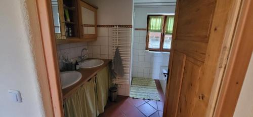 a small bathroom with two sinks and a window at Ferienhof Rindalphorn mit Sauna in ländlicher Idylle in Missen-Wilhams