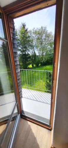 a sliding glass door with a view of a balcony at Ferienhof Rindalphorn mit Sauna in ländlicher Idylle in Missen-Wilhams