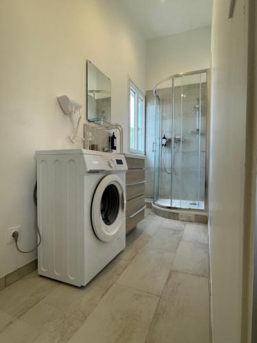 a washing machine in a bathroom with a shower at Massy Appart Hotel in Massy