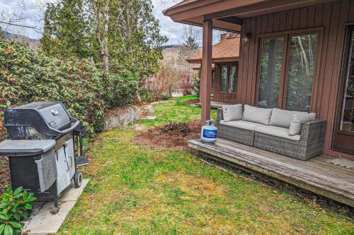 a porch with a couch and a grill on a house at Forest Hideaway in Waterville Valley