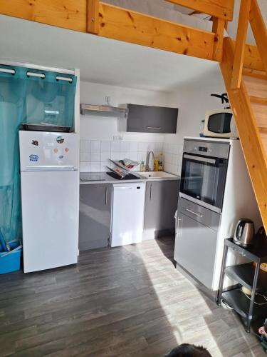 une cuisine avec des appareils blancs et un parquet dans l'établissement Appartement 2 pièces 33 m2 pour 4 personnes, à Saint-Jean-de-Monts