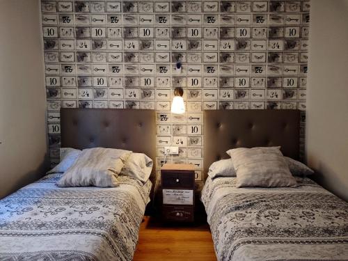 Dos camas en una habitación con una pared cubierta de dinero en Serendipia Apartamentos 1, en Logroño