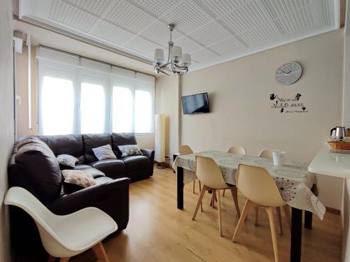 ein Wohnzimmer mit einem Sofa und einem Tisch in der Unterkunft Serendipia Apartamentos 1 in Logroño