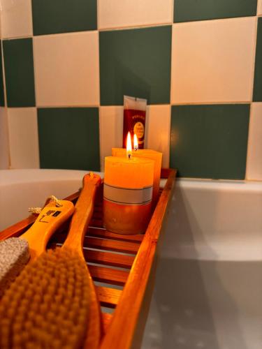 a candle sitting on a bench next to a bath tub at Mary’s Zagori boutique home in Ano Pedina