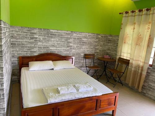 una camera con letto e parete verde di NHÀ NGHỉ HẬU NHI 