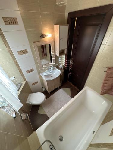ein Badezimmer mit einer Badewanne, einem WC und einem Waschbecken in der Unterkunft Domki Pod Brzoza in Idzików