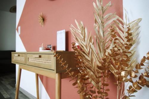 a wooden desk next to a pink wall with a plant at La belle Epoque in Damparis