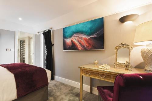 a bedroom with a bed and a table with a mirror at Aphrodites Group - Luxury Hot Tub Suites in Central Lake District! in Bowness-on-Windermere