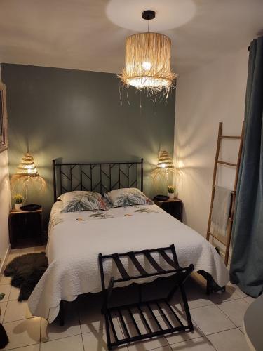 1 dormitorio con cama y lámpara de araña en L'échappée verte, en Parmain