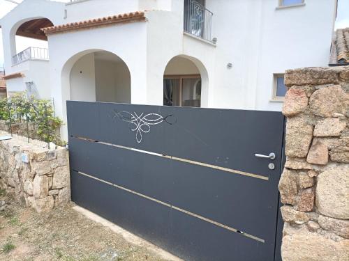 una puerta negra delante de una casa en Endless Summer Apartment en Olbia