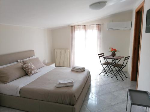 sypialnia z łóżkiem, stołem i krzesłami w obiekcie Rara Domus B&B w mieście Pompeje