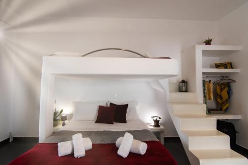 a bedroom with a bed with white walls and a staircase at Sea and sun in Kalamitsa
