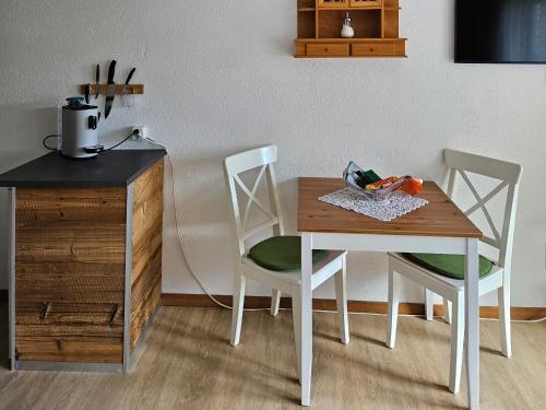 a wooden table with two chairs and a table with vegetables on it at Apartment Klein Matterhorn - Haus Miranda in Täsch