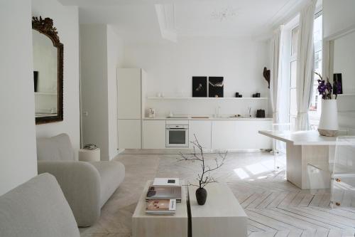 un salon blanc avec un canapé et une table dans l'établissement Opalin, à Paris