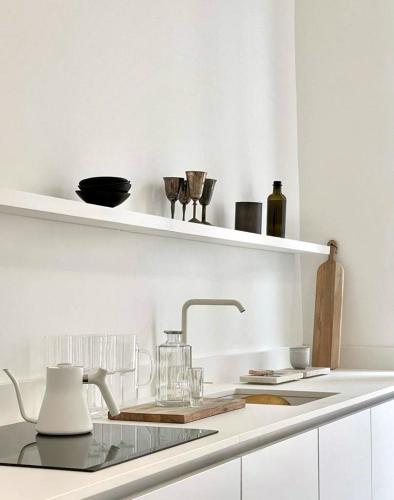 une cuisine blanche avec un évier et un plan de travail dans l'établissement Opalin, à Paris