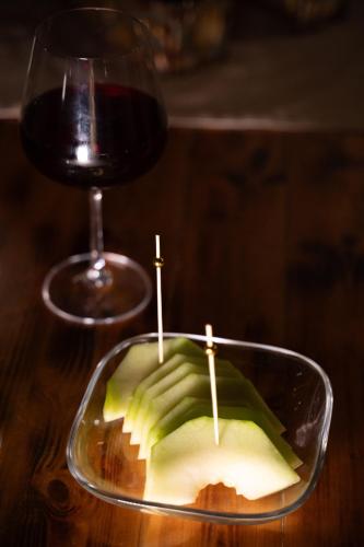 a glass of wine and an apple with two tooth picks at Sea and sun in Kalamitsa