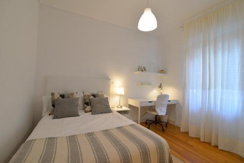 Habitación blanca con cama y escritorio en Apartamento en zona residencial cerca del Guggenheim, en Bilbao