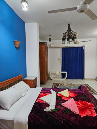 a bedroom with a bed with a blue wall at Egypt Villa Garden in Luxor