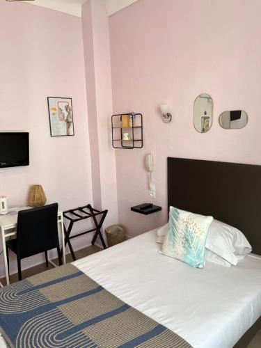 1 dormitorio con 1 cama y escritorio con ordenador en Hôtel Eden - La Baigneuse, en Juan-les-Pins