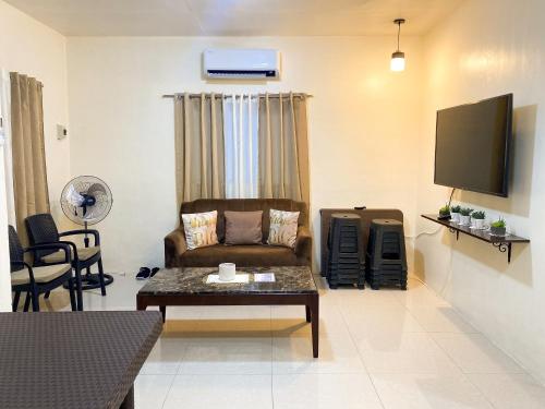 a living room with a couch and a tv at A&J Transient house (with wifi, Netflix & Disney+) in General Santos