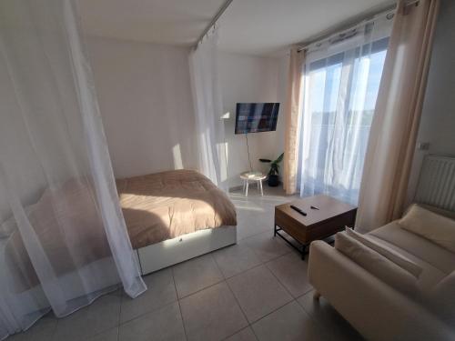 une chambre avec un lit et un canapé dans l'établissement Le cosy studio, à Épinay-sur-Seine