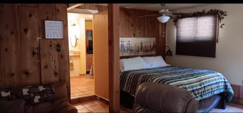 a bedroom with a bed and a chair in a room at 1948 Cottage with today's amenities in Bass Lake Annex