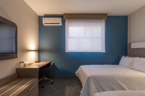 a bedroom with a bed and a desk and a window at Holiday Inn Express Morelia Centro Historico in Morelia