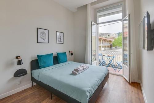 une chambre avec un grand lit et une grande fenêtre dans l'établissement BRP Cannes Center, Four-Bedroom Deluxe Apartment, à Cannes
