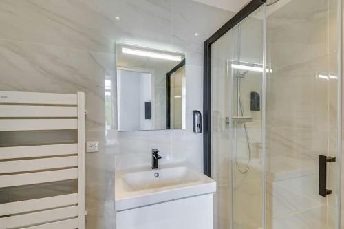 une salle de bain blanche avec un lavabo et une douche dans l'établissement BRP Cannes Center, Four-Bedroom Deluxe Apartment, à Cannes