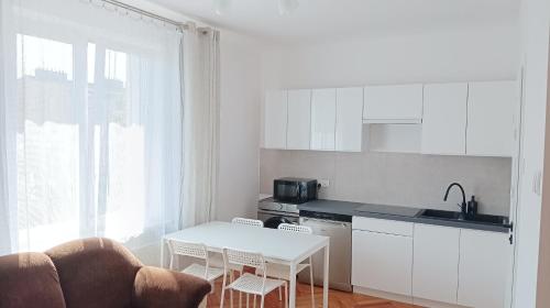 kuchnia z białym stołem i białym blatem w obiekcie Hoffberg Apartment w przyziemiu (ground floor) w mieście Lublin