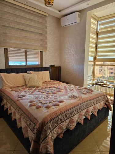 a bedroom with a large bed with a large window at L'horizon Aéroport Appartement in Marrakech