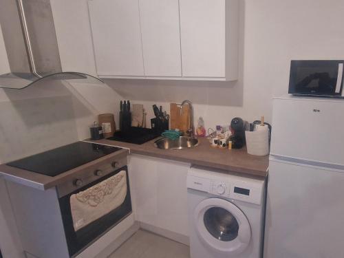 une cuisine avec un lave-linge et un lave-vaisselle dans l'établissement Le cosy studio, à Épinay-sur-Seine