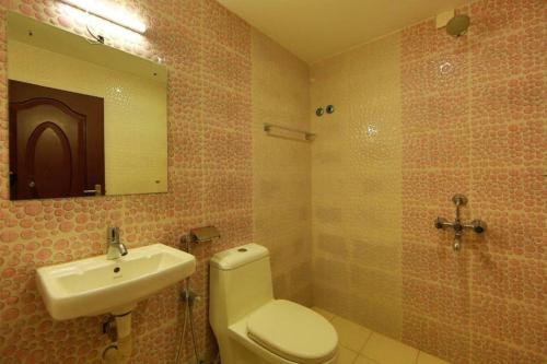 La salle de bains est pourvue de toilettes, d'un lavabo et d'un miroir. dans l'établissement Gman apartment, à Amman