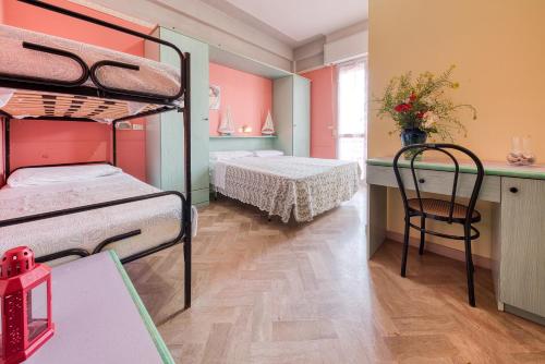 a room with two bunk beds and a table at Hotel Sabbia d'Oro in Rimini