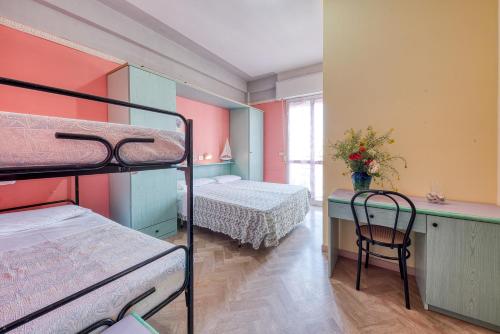 um quarto com 2 beliches e uma secretária com uma mesa em Hotel Sabbia d'Oro em Rimini