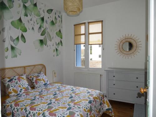 une chambre avec un lit, une fenêtre et un miroir dans l'établissement La petite royannaise, à Royan