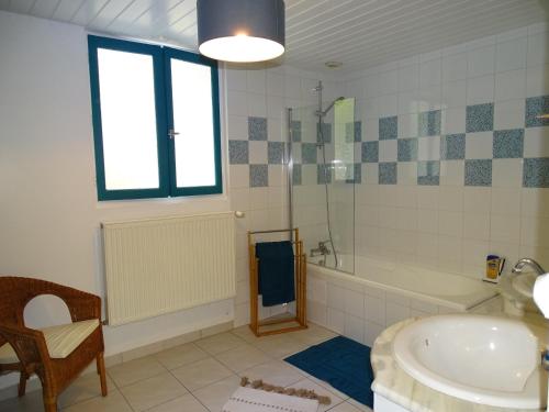une salle de bain avec une baignoire et un lavabo dans l'établissement La petite royannaise, à Royan