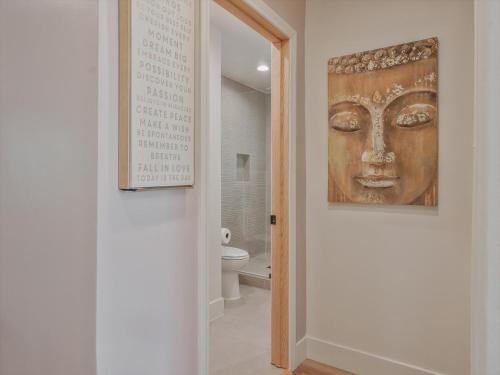 a bathroom with a painting of a face on the wall at Hollywood Dream pool home & king beds in Los Angeles