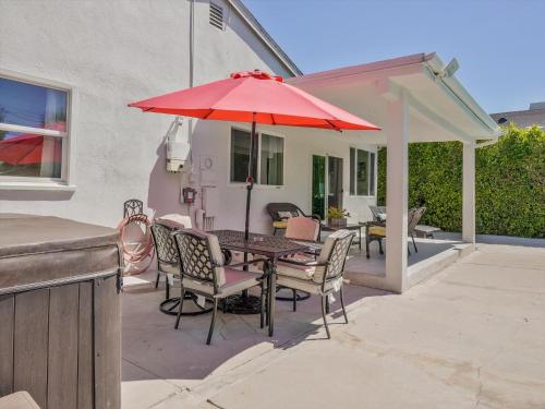 a patio with a table with a red umbrella at Hollywood Dream pool home & king beds in Los Angeles