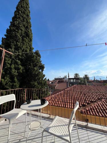 eine Terrasse mit 2 Stühlen, einem Tisch und einem Baum in der Unterkunft Erkal Pension in Antalya