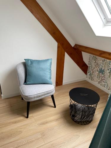 a chair with a blue pillow sitting in a room at La Paulerie in Wacquinghen