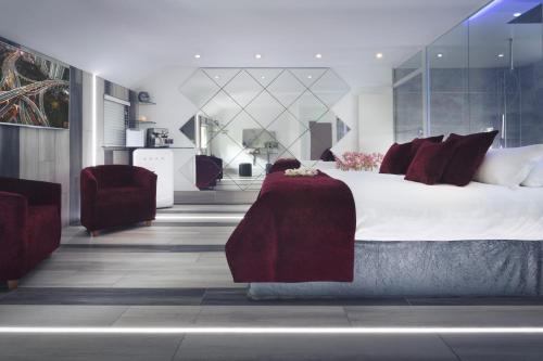 a bedroom with a large bed with red pillows at Aphrodites Group - Luxury Hot Tub Suites in Central Lake District! in Bowness-on-Windermere