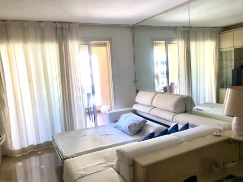 a living room with a couch and a large mirror at Monaco, elegant & quiet renovated apartment, with terrace & pool, 15min walk to Port Hercule in Monte Carlo