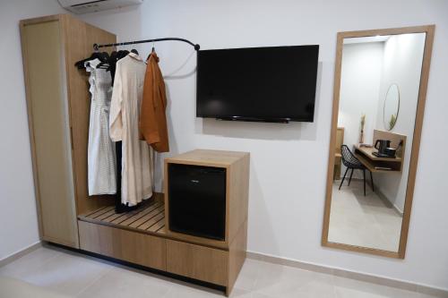 a room with a tv on a wall with a mirror at Tropical Beach A in Amoudara Herakliou