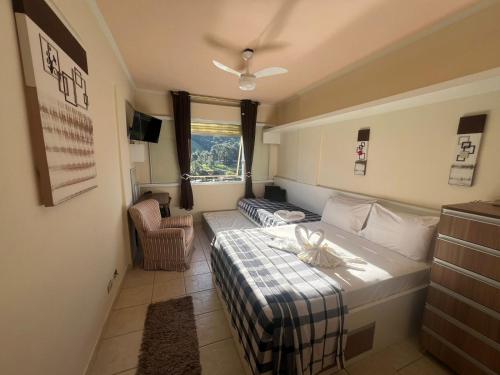 een hotelkamer met een bed en een raam bij FLAT CAVALINHO BRANCO-ÁGUAS DE LINDOIA in Águas de Lindóia