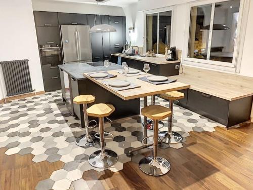 une cuisine avec un grand îlot et des tabourets de bar dans l'établissement Appartement type industriel centre ville, à Vannes