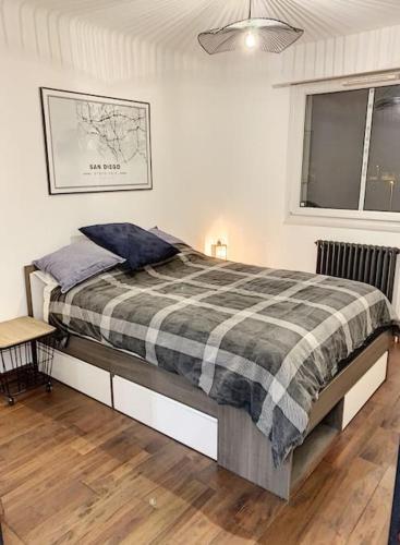 une chambre avec un lit avec une couverture à carreaux dans l'établissement Appartement type industriel centre ville, à Vannes